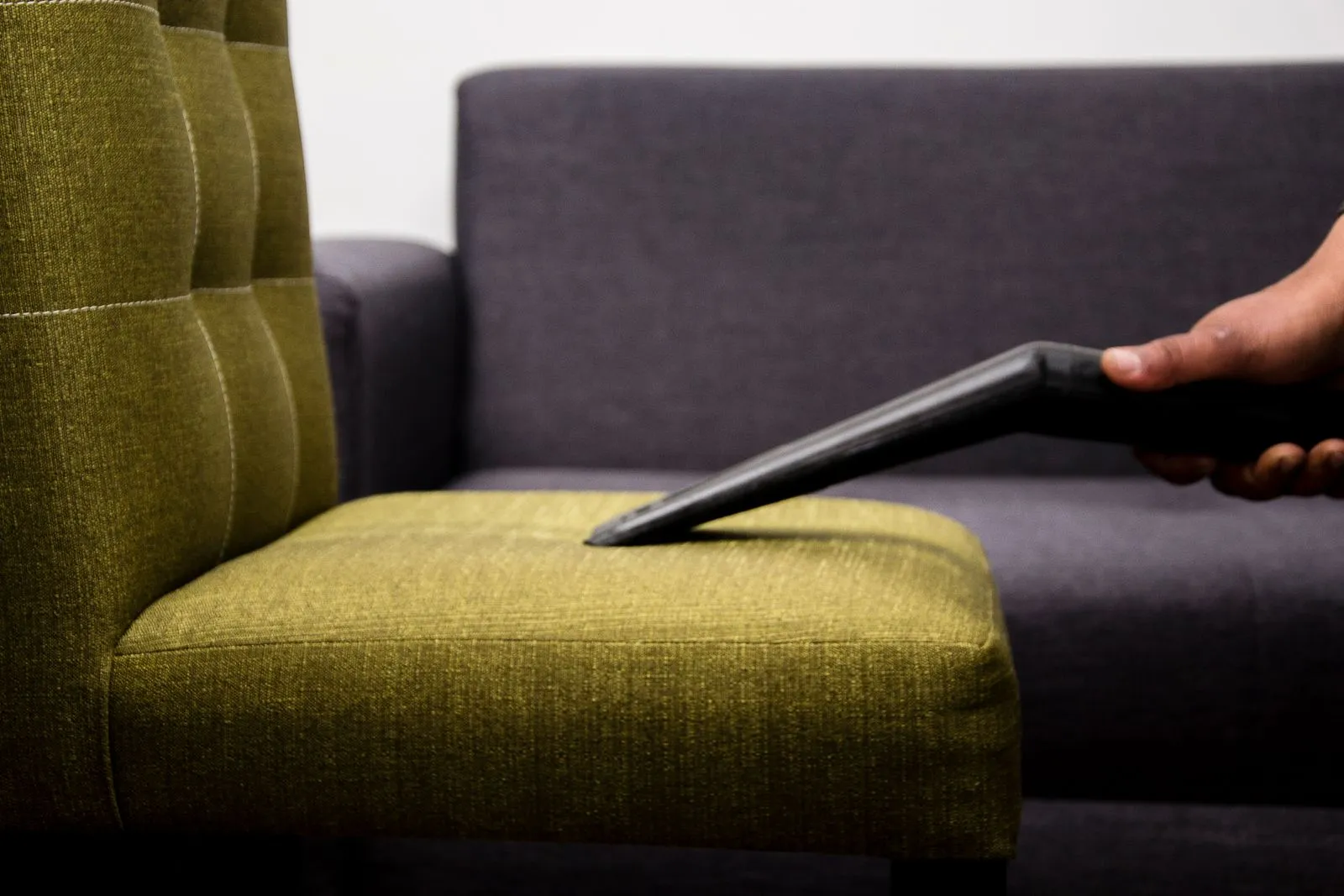 Upholstered chair being vacuumed